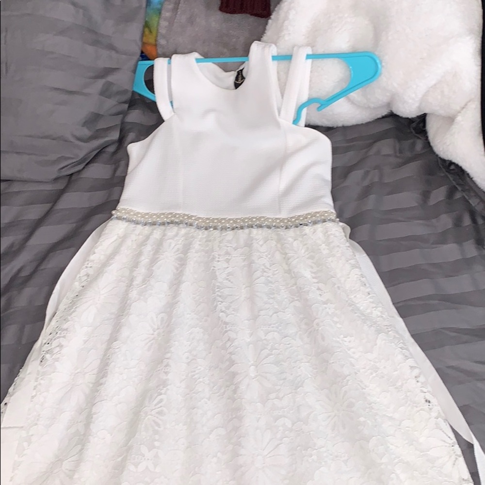 Kids white dress with a jewel belt in the front.